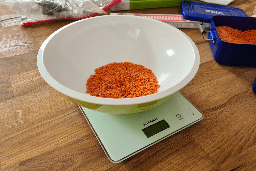 Грязь взвешивается на весах во время испытания мощности всасывания Dreame L20 Ultra.